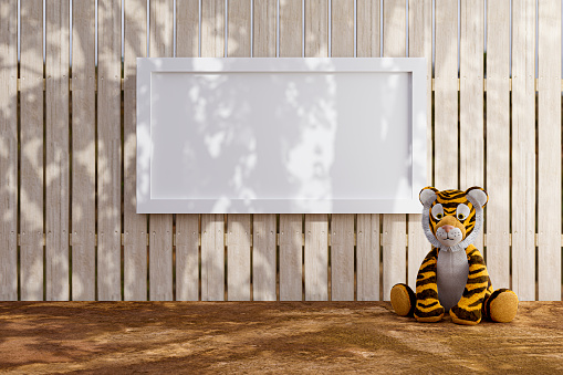 3d rendered illustration of a white picket fence with white mock up poster frame and stuffed toy tiger.