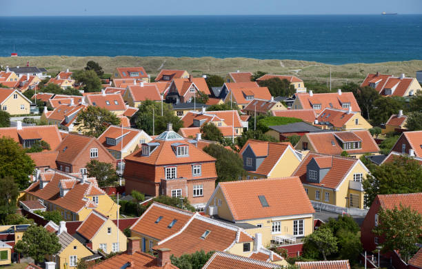 Aerial view of family houses with garden one sunny morning. Residential district with traditional detached houses brick build and painted yellow with red tile roofs near Skagerrak.