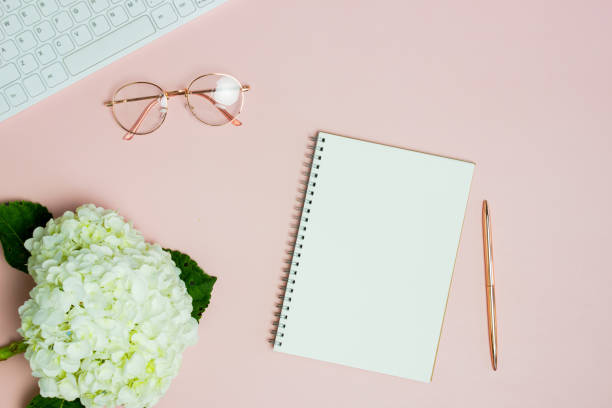 istock Woman working space with notebook, computer and flowers on pink background. 1405572008
