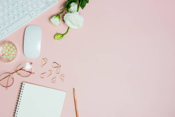 istock Working items with notebook, computer, pen and roses over the pink background. 1405572042
