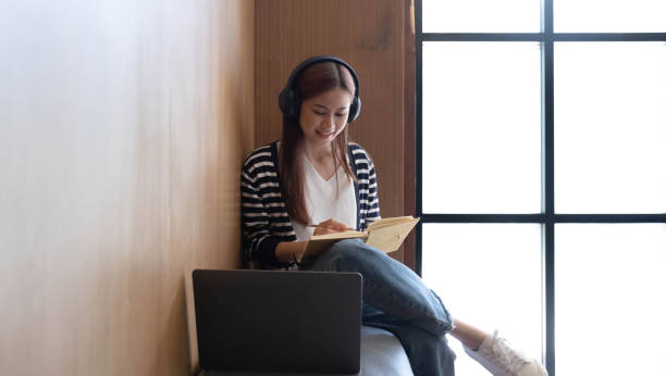 istock Young students use computers to study online. online education and learning Asian woman uses laptop technology while sitting at her desk and doing creative work. work from home concept 1405573670