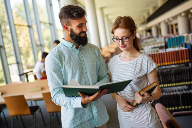 istock Happy group of students studying and working together in a college library 1405574308