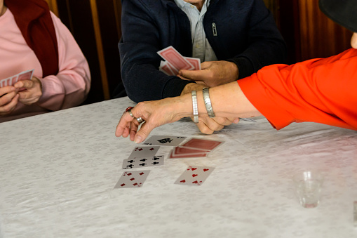 While playing cards at a social meeting, a group of seniors is having a great time.