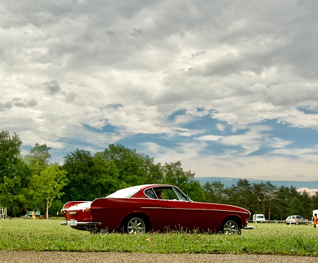 Sixties famous volvo P1800 with a dramatic sky in the background. This is an electric  retrofit car.