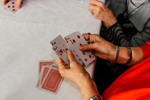 An active group of seniors is playing cards at a social gathering. They are having a great time.