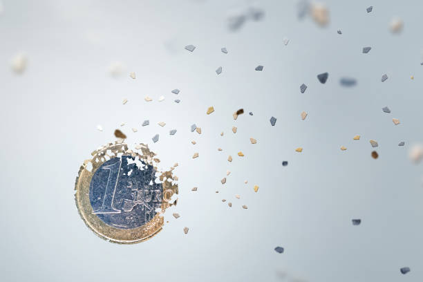 1 Euro coin breaking into pieces Economic concept. One Euro Coin breaking into small pieces. Isolated on neutral background. inflation stock pictures, royalty-free photos & images