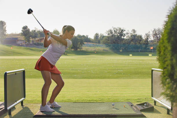 istock beautiful girl makes a hit while playing golf 1405579241