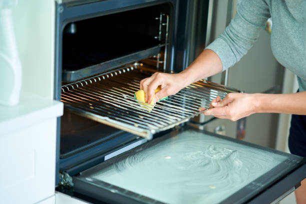 istock Young woman cleaning oven in the kitchen 1405580052