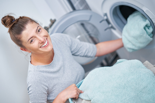 Picture of young woman making laundry work. High quality photo