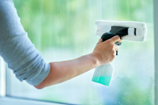 istock Young woman cleaning window int he kitchen 1405582718