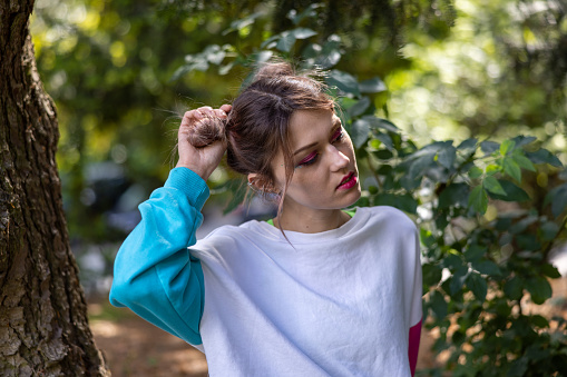 LGBTQ+ girl styling her unique haircut style as a powerful tool for self-expression, giving the confidence needed to get by in a world where acceptance is difficult.