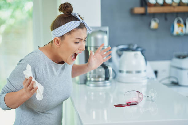 istock Young woman and spilled wine in the kitchen 1405583222