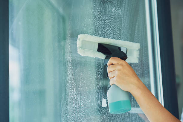 istock Young woman cleaning window int he kitchen 1405583572
