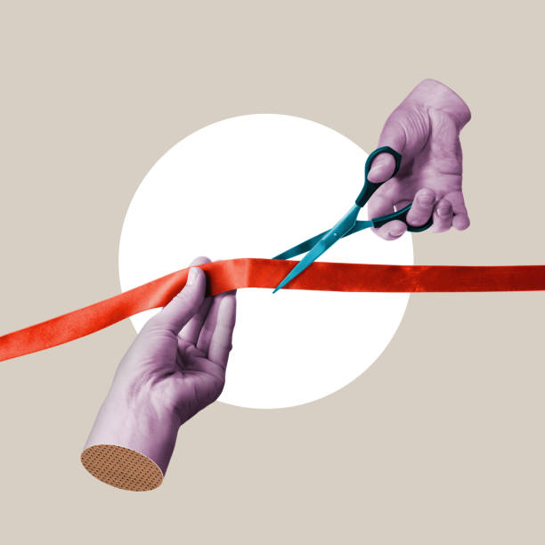 Isolated scissors cutting red ribbon on white background