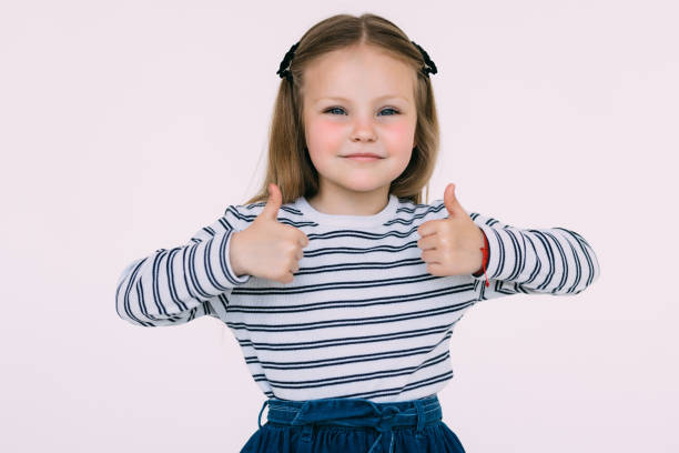 istock Small kid giving two thumbs up on white background 1405584362