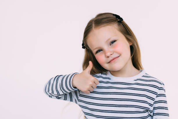 istock Small kid giving two thumbs up on white background 1405584588