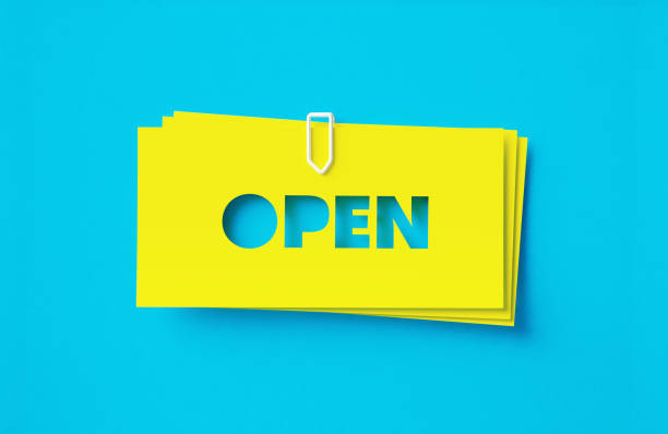 Open written cut out yellow adhesive notes sitting on turquoise background. Horizontal composition with copy space.