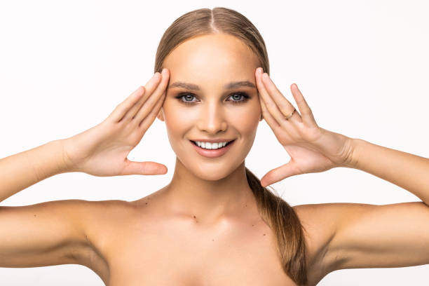 istock Young pretty woman touching her face isolated on white background 1405590947