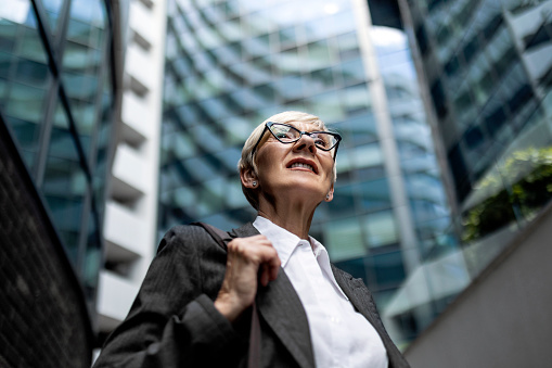 Mature businesswoman walking outside office building