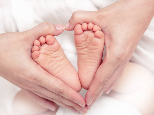 istock Baby's foot in mother hands closeup 1405592644