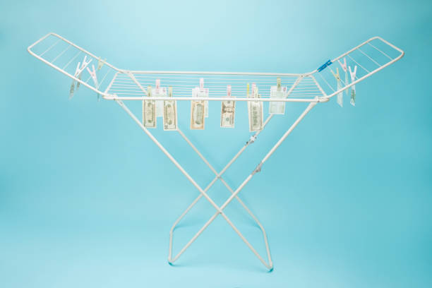 Dollar and euro banknotes weigh on a clothes dryer. Money laundering concept.
