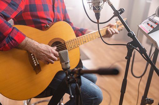 Seasoned Session Musician Recording a Live Session On An Acoustic Guitar In The Studio