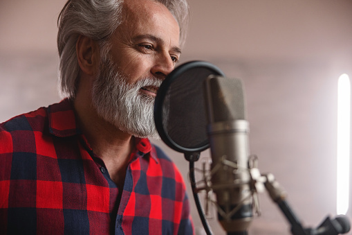 Portrait Of A Mature Adult Singer Recording In A Recording Studio
