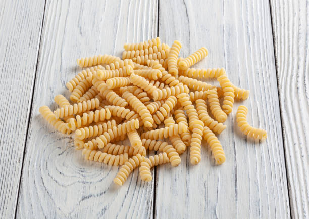 istock Uncooked fusilli pasta on white wooden background 1405595842