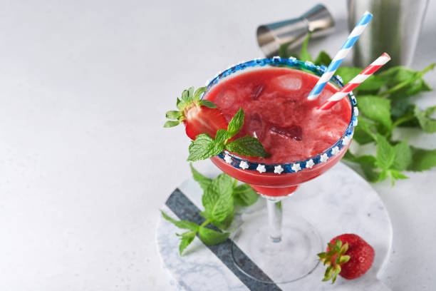 cocktail patriotique le 4 juillet. cocktail margarita en verre avec fraise, menthe et glacé. boissons pour la célébration du jour de l’indépendance américaine. - flag glass striped fourth of july photos et images de collection