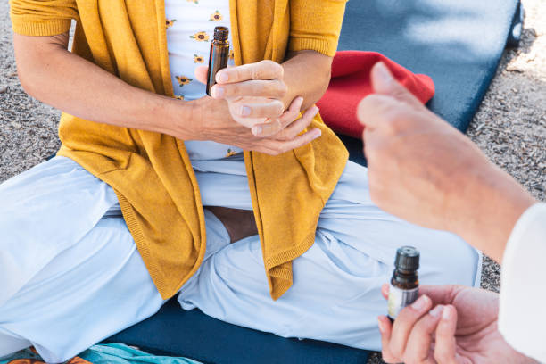 夏のマインドフルネスの儀式でアロマサーピーオイルをテストする女性。 - yoga outdoors hippie people ストックフォトと画像