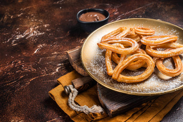 istock Spanish dessert churros with hot spicy chocolate. Dark background. Top view. Copy space 1405598436
