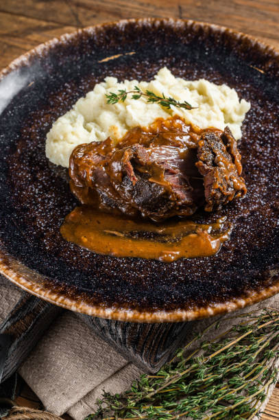 istock Beef cheeks stewed in red wine sauce with mashed potatoes. Wooden background. Top view 1405599307
