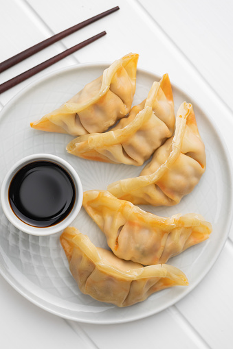 Chinese dumplings and soy sauce on a plate. Top view.