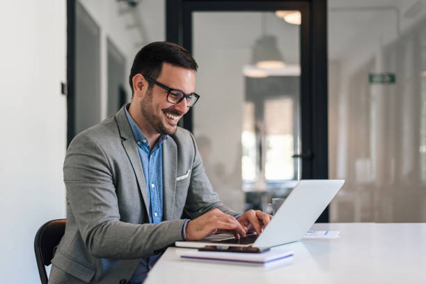 istock Cheerful business professional working on laptop while sitting at office desk 1405602526