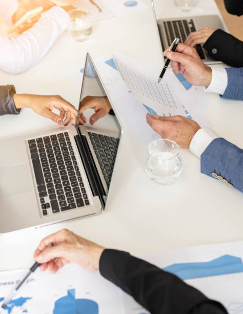 istock Group of multiethnic busy people working at an office work desk with charts 1405603131
