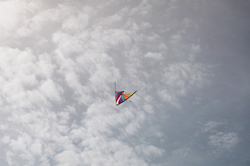 colorful kite flying with waving in blue sky with the light of the sun.  lifestyle