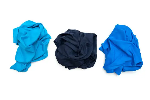 Three crumpled twisted blue sport t-shirts isolated on white, top view