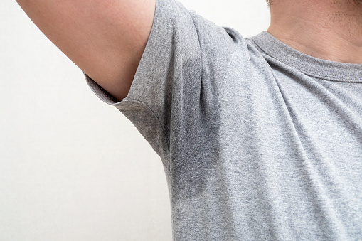 Sweaty armpit, wet underarm wet stain on grey t-shirt
