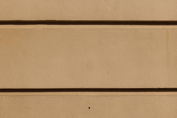 Part of a textured beige concrete wall with channels.