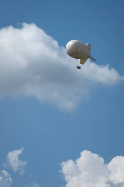 istock Airship in a blue sky with scattered white clouds. 1405605979