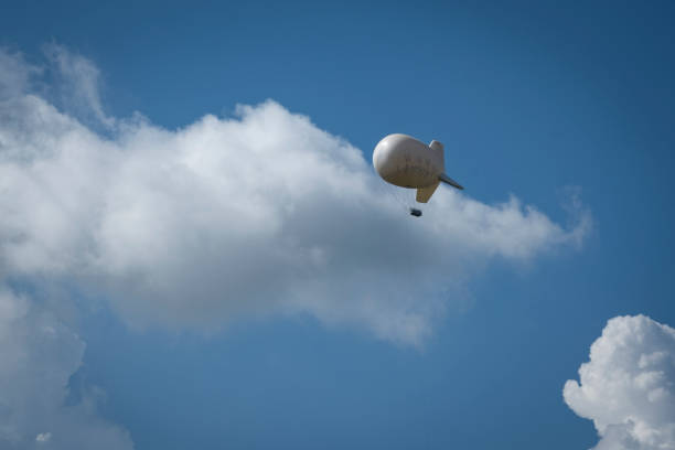 istock Airship in a blue sky with scattered white clouds. 1405605988