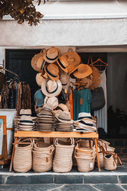 traditioneller dorfladen mit hüten und strohtüten, körben und kleidung auf der straße. handgefertigte souvenirprodukte für sommertouristen - cadaques stock-fotos und bilder