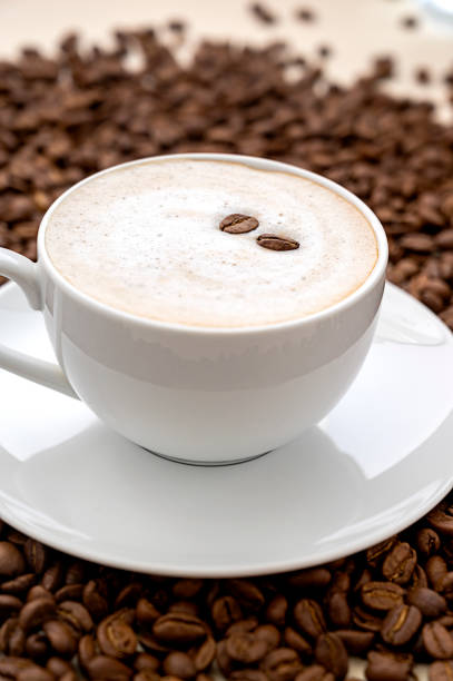Coffee abstract, coffee cup and coffee beans beans on warm, neutral background