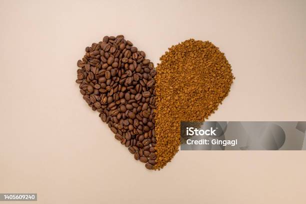 Abstract Coffee Concept Ground Instant Coffee And Coffee Beans In Heart Shape On Warm Neutral Background Stock Photo - Download Image Now