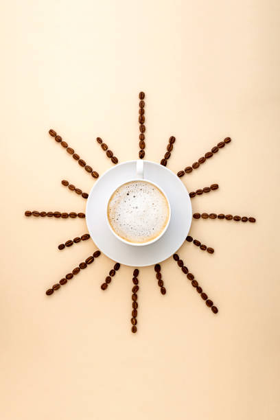 Coffee abstract, creative concept, coffee cup and coffee beans beans on warm, neutral background
