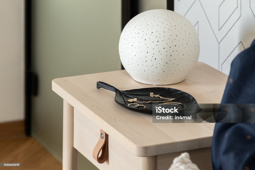 Stylish decoration on wooden bedside table, close-up Close-up on stylish decoration on wooden bedside table with small drawer Night Table Stock Photo
