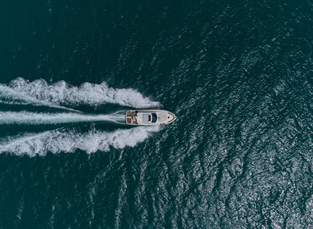 Aerial top down view of speed motor boat on open sea at summer day stock photo