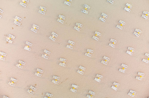 Aerial view of empty sandy beach with beach umbrellas and chairs at summer day. Black sea, Bulgaria Aerial top view of an amazing empty sandy beach with beach umbrellas and chairs at summer day. Black sea, Bulgaria beach umbrella aerial stock pictures, royalty-free photos & images