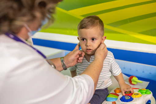 A mature female doctor examining a child in a children's hospital