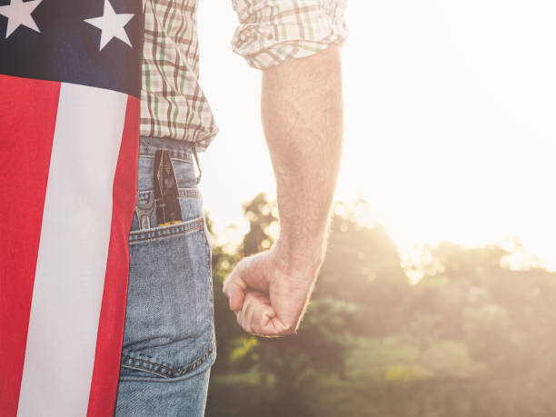 istock Attractive man in work clothes, holding American Flag 1405610856